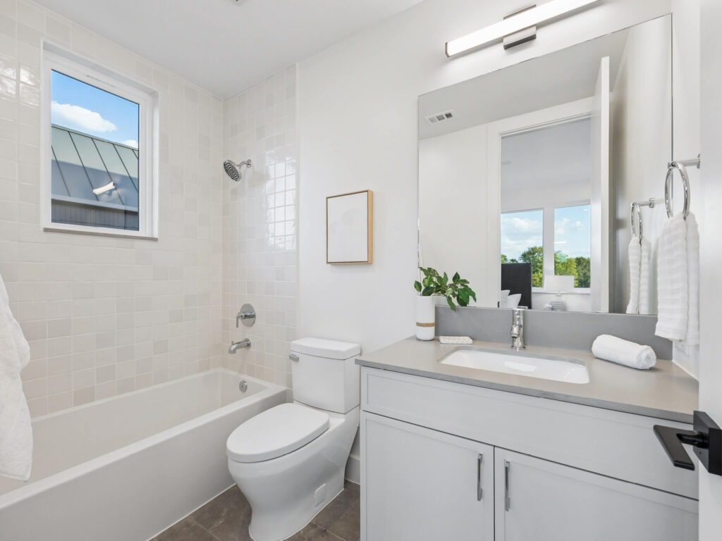 Interior view of modern townhome bathroom with bathtub and toilet at 4101 Menchaca Road, Austin, TX 78704